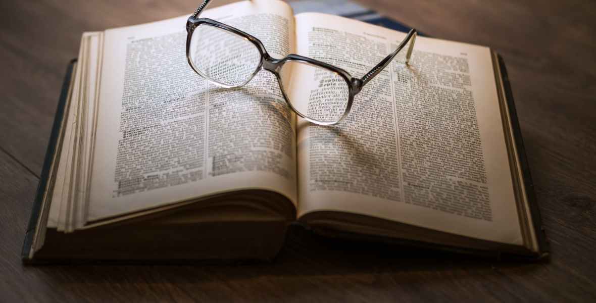 a pair of spectacles resting on an open book